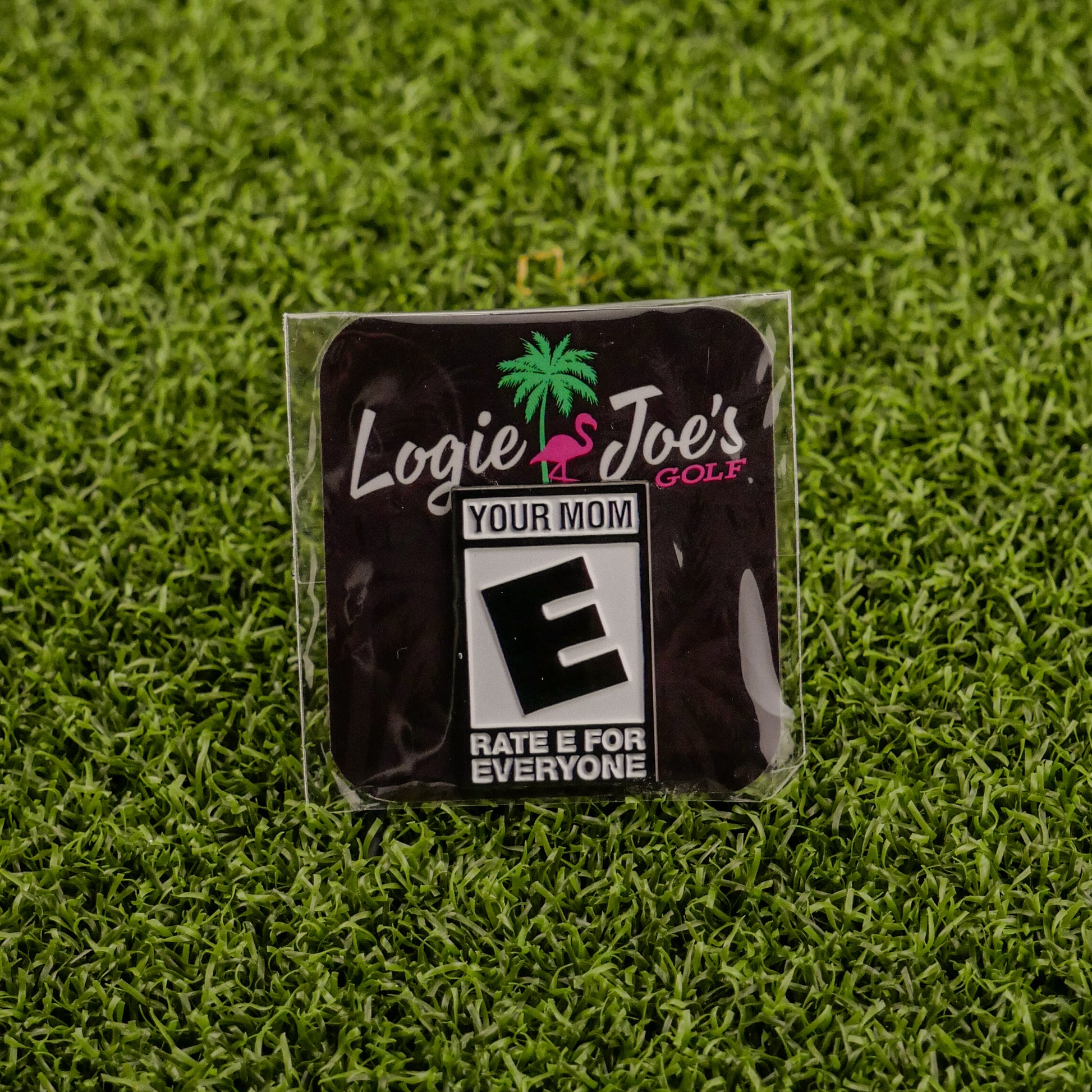 Ballmarkers by Logie Joe’s offers the “Your Mom ‘Rated E’” premium ball marker featuring a pink flamingo, palm tree, and vibrant text—ideal for golf lovers seeking unique and funny accessories.