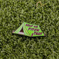 Ball markers by Logie Joes: A green enamel ball marker shaped like a pitched tent with HELP ME PITCH THAT in bold red letters, shown on artificial green grass.