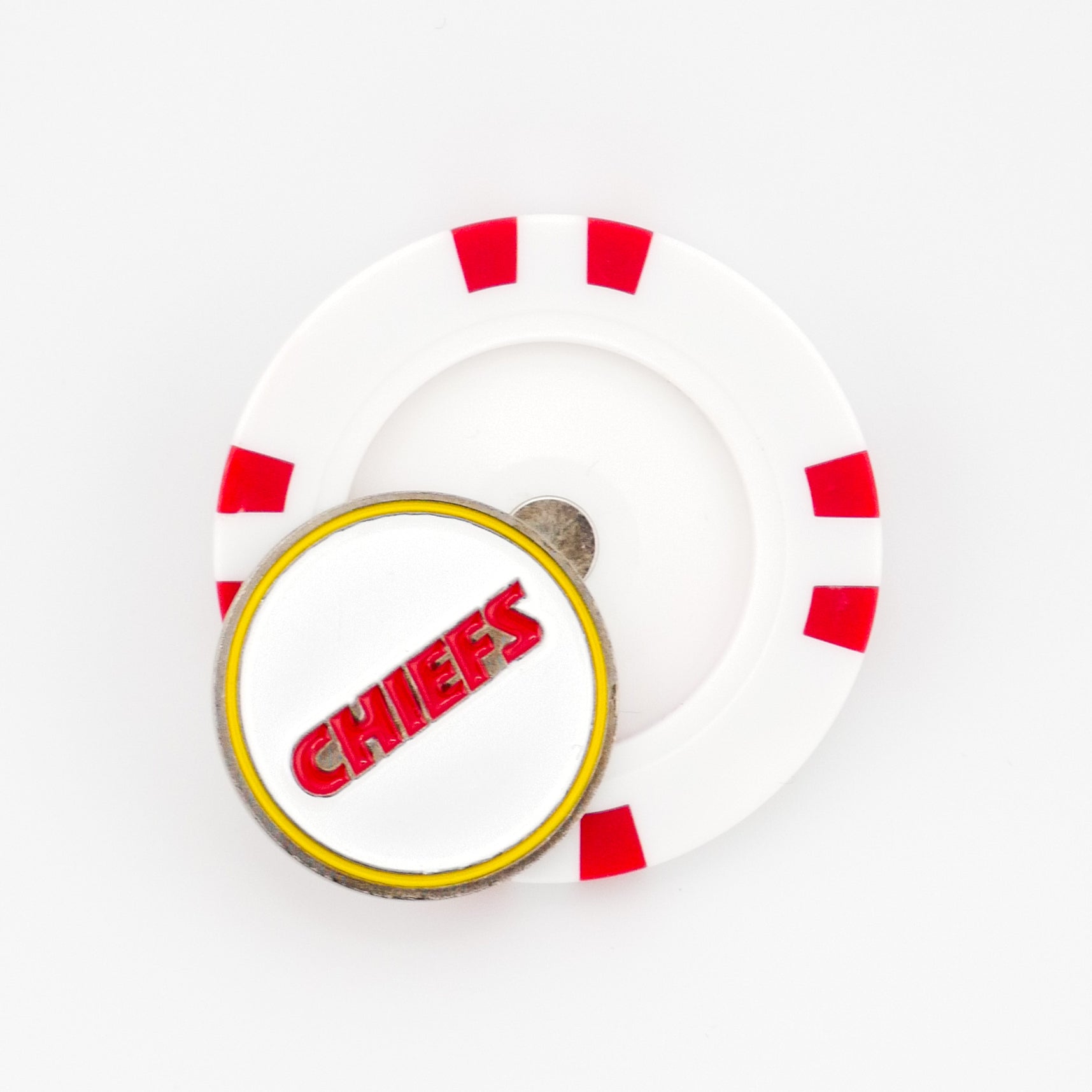 A Ballmarkers by Logie Joes Kansas City Chiefs set featuring a white poker chip ball marker with red accents and a round Chiefs pin with bold red letters outlined in yellow on top of the chip.