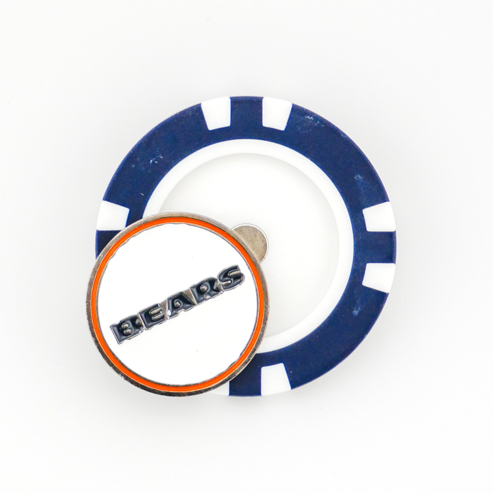 A blue and white poker chip ball marker and a round Chicago Bears pin with an orange outline by Ballmarkers from Logie Joes rest on a white surface—an eye-catching addition to your golf accessories.